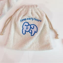 Kosmetikkveske med snøring i imitert lammeull Hvit