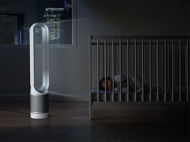 Ett barn som sover bredvid en Dyson Pure Link luftrenare.