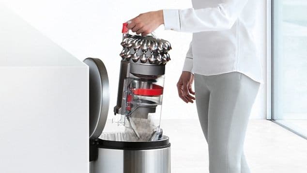 En person som tömmer Dyson dammbehållare