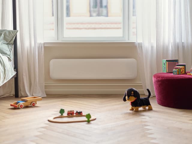 Mill Invisible på en vägg och leksaker på golvet