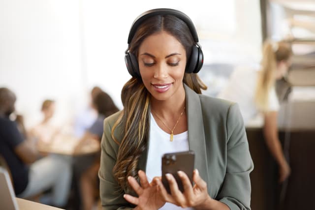 Jabra - Kvinde med Evolve2 75 kigger på en telefon