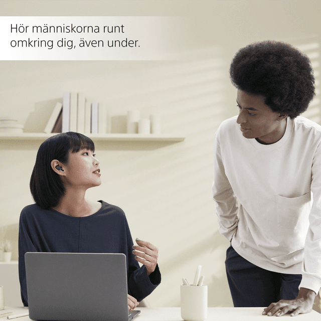 Kvinna med Sony LinkBuds pratar med en man på ett kontor
