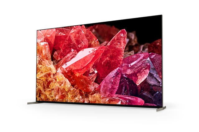 Sony-X95K TV-skärm på stativ som visar röd- och gultonade ädelstenar