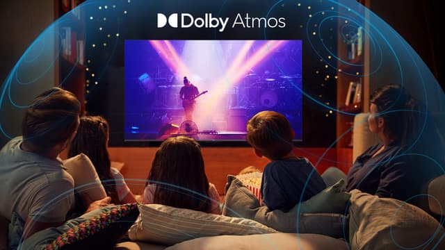 TCL P73 TV-skärm som visar en person som spelar gitarr på en scen och en familj med tre barn och två vuxna i en soffa