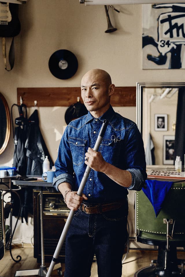 Man holding a broom in a hair salon