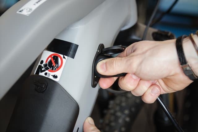 Person der tilslutter sin en oplader til en elcykel