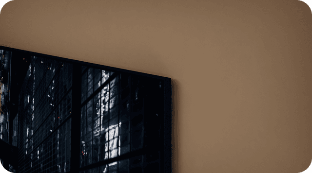 Nærbilde av hjørnet av Samsung Neo QLED TV på en beige vegg