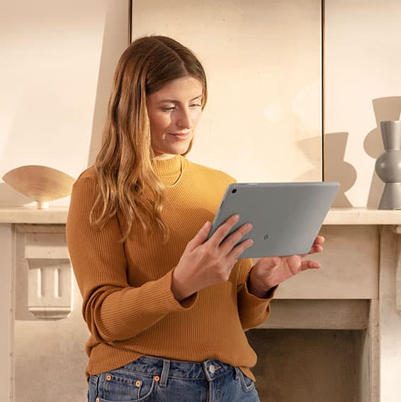 Kvinne som bruker Google Pixel-nettbrett i hjemmet sitt