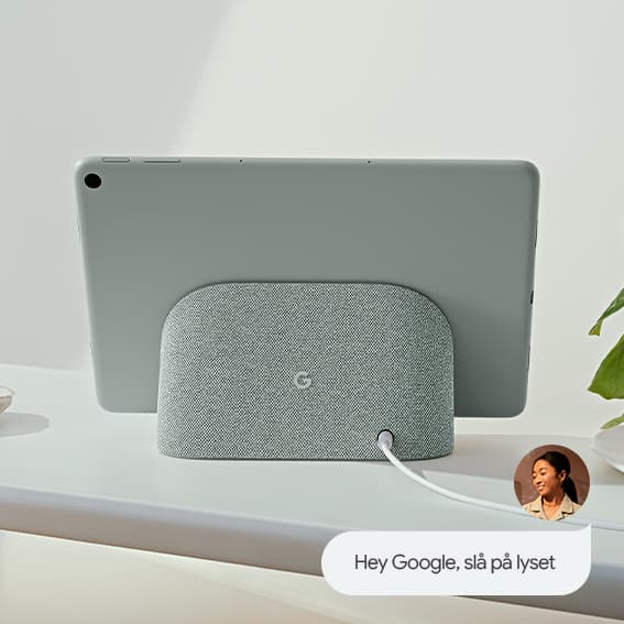 Pixel-nettbrett i ladestasjonen med høyttaler og en kvinne som sier Hey Google, slå på lysene