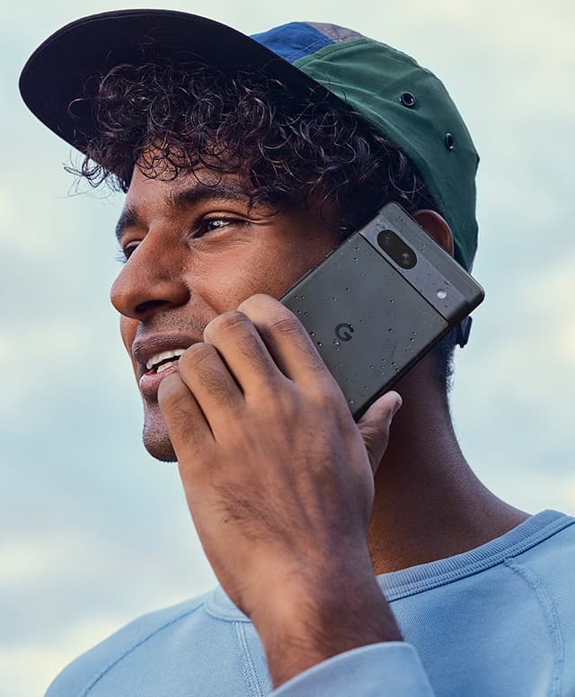 Man in cap talking into a Google Pixel 7a