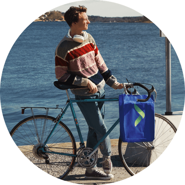 Ung person med en cykel med en Elgiganten-pose på styret