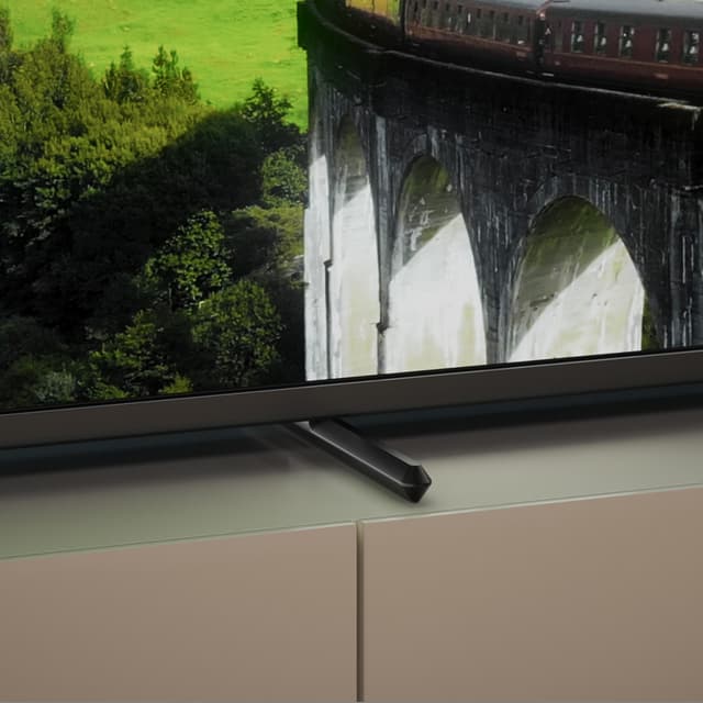 Lähikuva Philips PUS7608 -television alareunasta, jossa näkyy sen kehys ja jalusta