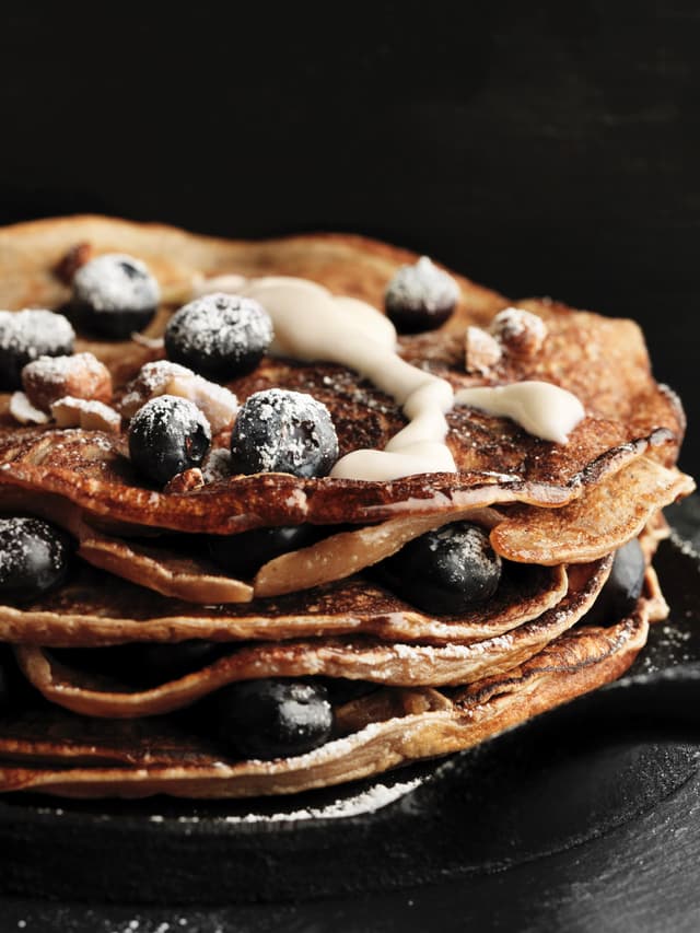 Pancake Day 2024 - Stacked pancakes with blueberries, cream, and powdered sugar