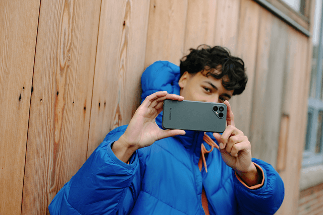 Fairphone 4 med forbedret kamerafunksjoner i hånden på gutt som tar et bilde