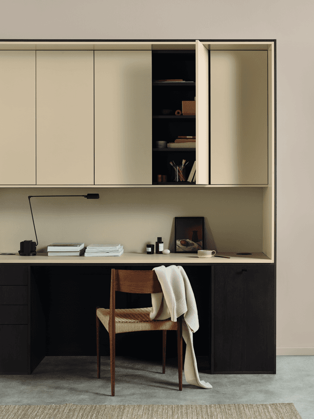 Køkken som kontor i mørkt træ og beige og en stol
