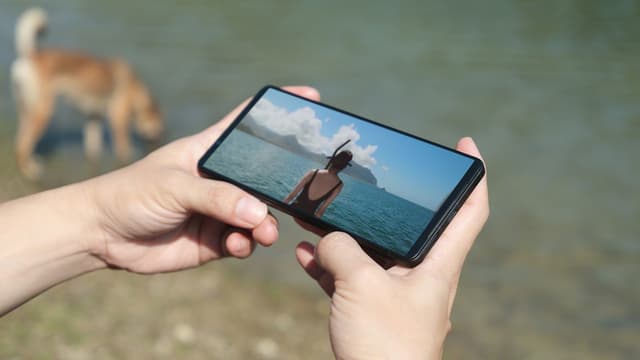 Henkilö pitelee Sony Xperia 1 VI -puhelinta kädessään ja katselee videota sen kirkkaalta näytöltä