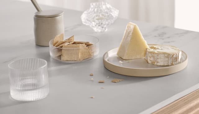 Grå benkeplate der det står ost og kjeks klar til servering