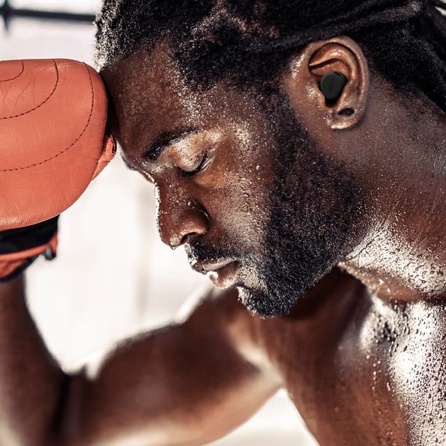 Jabra Elite 8 Active G2 og mann med boksehansker lent mot veggen