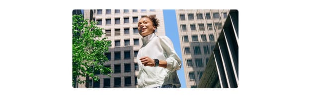 En kvinna i träningskläder som bär en Galaxy Watch7 i ett stadskvarter