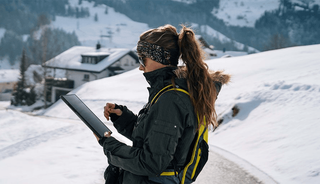 En kvinde i bjergene i sneen med ASUS ProArt PZ13 laptop