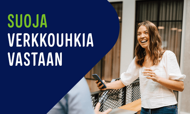 Hymyilevä nainen seisoo yrityksen käytävällä puhelin kädessään, sekä teksti; Suoja verkkouhkia vastaan