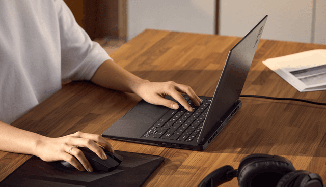Henkilö käyttää pöydällä olevaa Asus TUF Gaming 14 FA401kannettavaa tietokonetta
