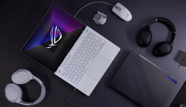 Asus ROG Zephyrus G16 på et bord med 2 headsett og mus