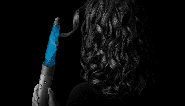Nainen käyttää Dyson Airwrap™ multi-styler  -muotoilulaitetta ja kuivaajaa hiustensa muotoiluun