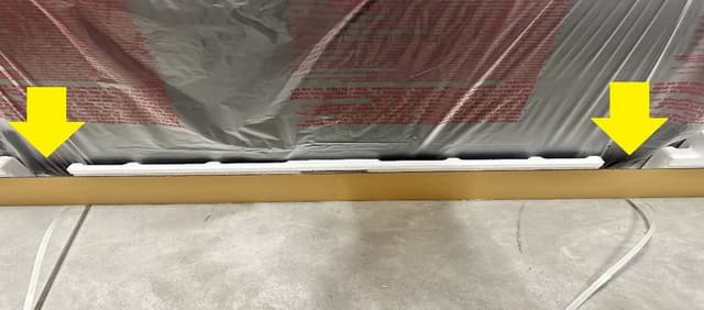TV in package with yellow arrows that point to where to grip TV