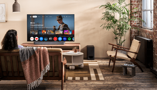 Sony Bar6 - BRAVIA Theatre Bar 6E 3.1.2 i en stue og en kvinde på sofaen, der ser TV