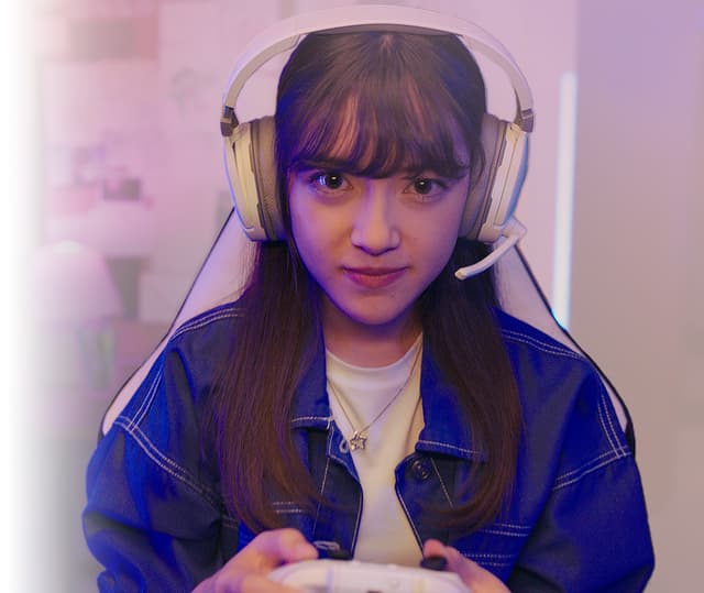 AMD - Microsoft - CoPilot - kvinde sidder med høretelefoner og gamer