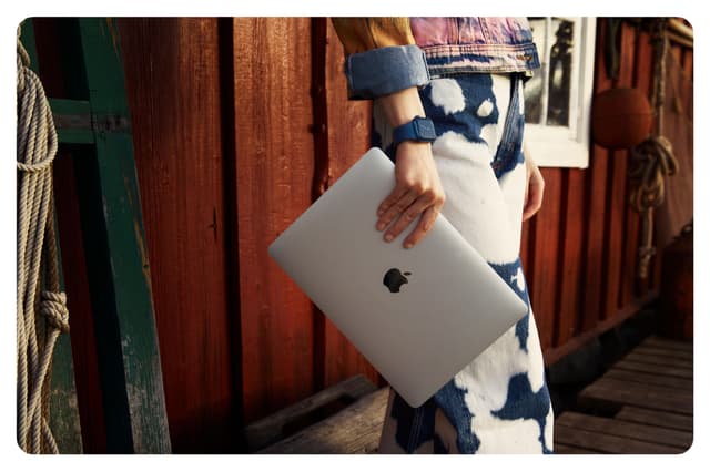 Apple - Trade In - Hand som håller en Macbook Pro