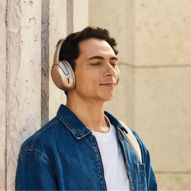 A man with closed eyes wearing wireless JBL TOUR ONE M3 noice cancelling headphones