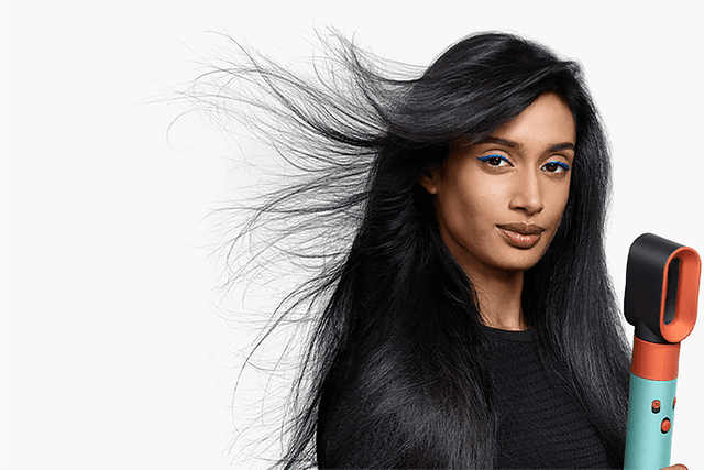 Dame med mørkt hår bruker Dyson Airwrap™ multi-styler og dryer for styling