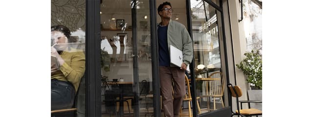 AI-PC under armen på en mand på en café