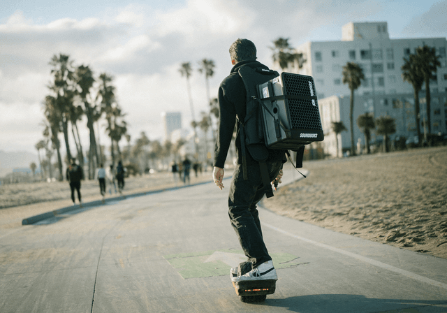 Bærbar Soundboks Go-højttaler på ryggen af en mand på skateboard