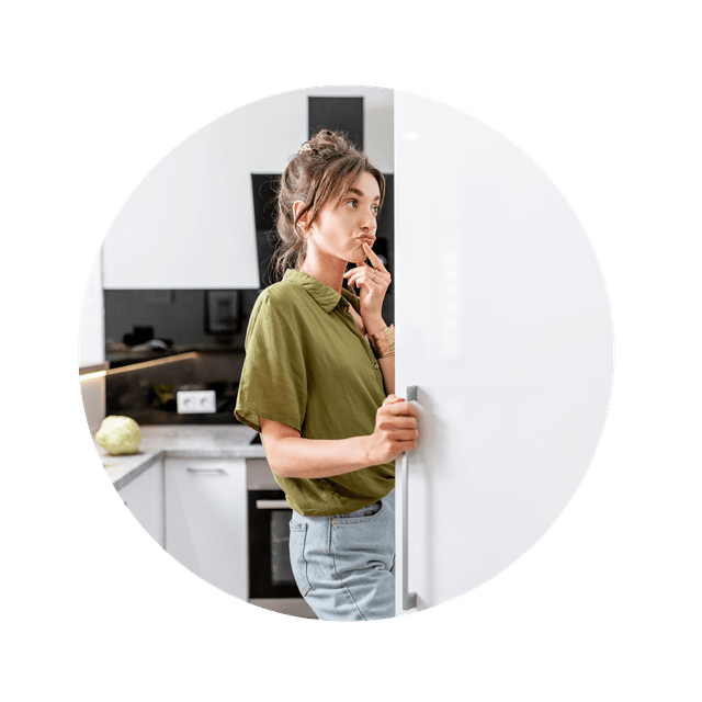Woman in front of a open freezer and looking hesitant