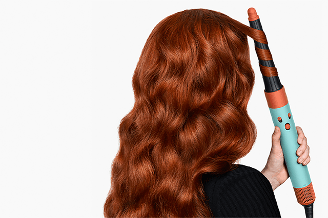 Red-headed woman using Dyson Airwrap™ multi-styler and dryer for hair styling - Conical barrel