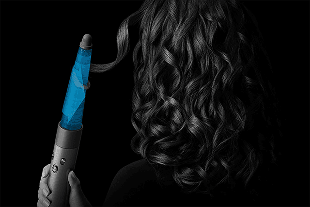 Woman styling her hair with Airwrap i.d.™ multi-styler