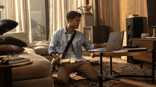 HP AI-PC anvendes af mand, som sidder med elguitar