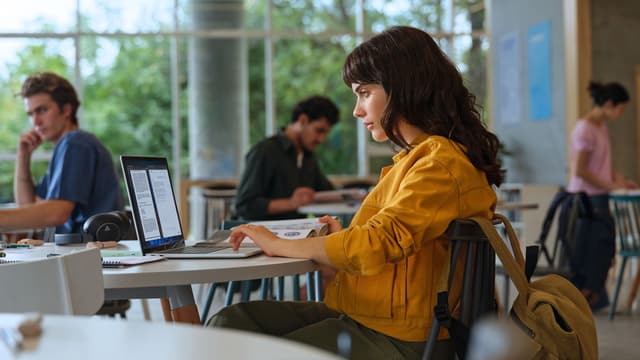 Jente jobber på kafe med en HP Omnibook PC