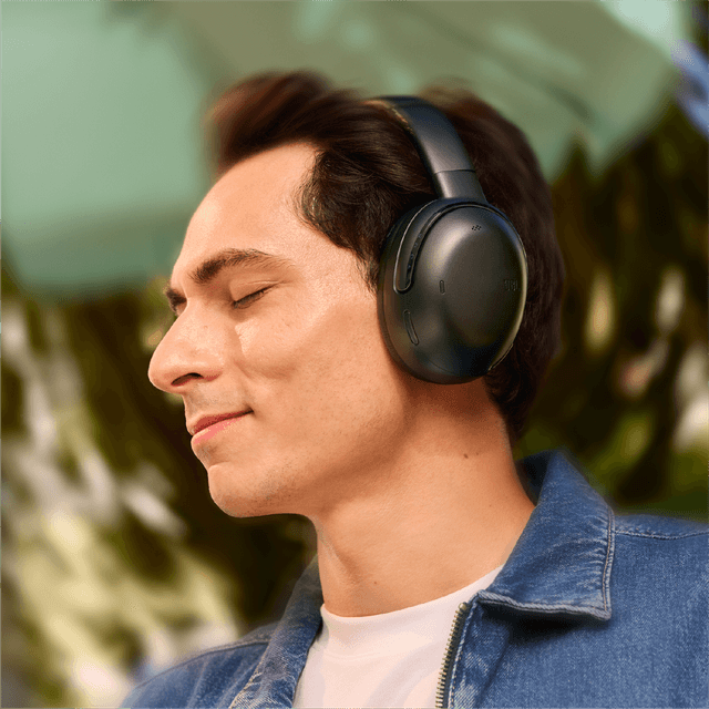 JBL TOUR ONE M3TX på hovedet af mand med smil på læben og lukkede øjne