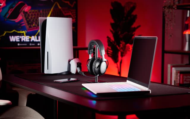 Mustat HyperX Cloud III S Wireless -pelikuulokkeet Playstation 5 -pelikonsolin ja pelitietokoneen vieressä