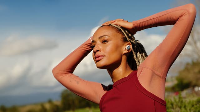 Tyttö valkoiset Bose QuietComfort Ultra Earbuds -nappikuulokkeet päässään