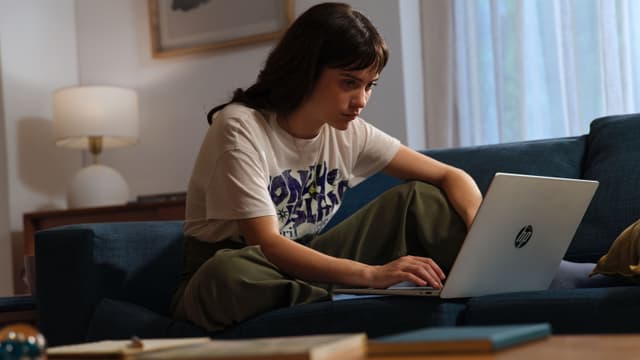 HP OmniBook 5 14" anvendes af kvinde, som sidder i sofa