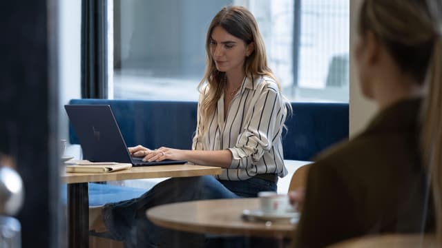 HP OmniBook X Flip 14" anvendes af kvinde på café