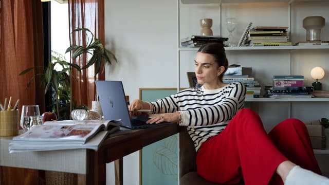 HP OmniBook X Flip 14" anvendes af kvinde ved skrivebord