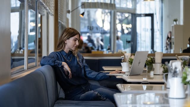 HP OmniBook X Flip 16" anvendes af kvinde på café
