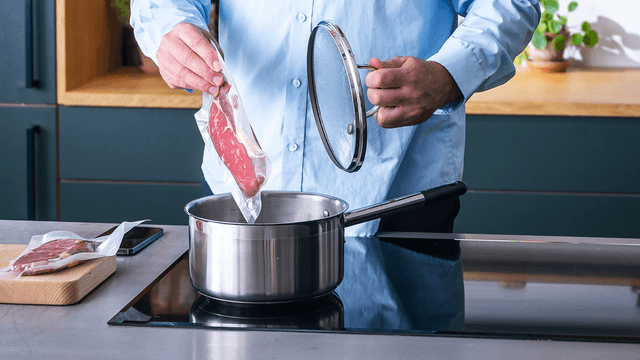 Mies valmistaa ruokaa Sous vide -tekniikalla keittotason päällä