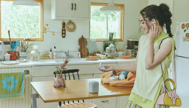 LinkBuds Speaker on a kitchen table next to a girl who is wearing Sony LinkBuds